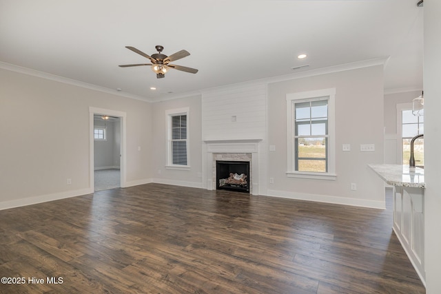 unfurnished living room with a fireplace, dark hardwood / wood-style flooring, ceiling fan, and crown molding