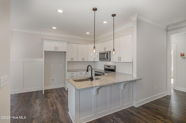 kitchen featuring sink, hanging light fixtures, stainless steel appliances, kitchen peninsula, and white cabinets