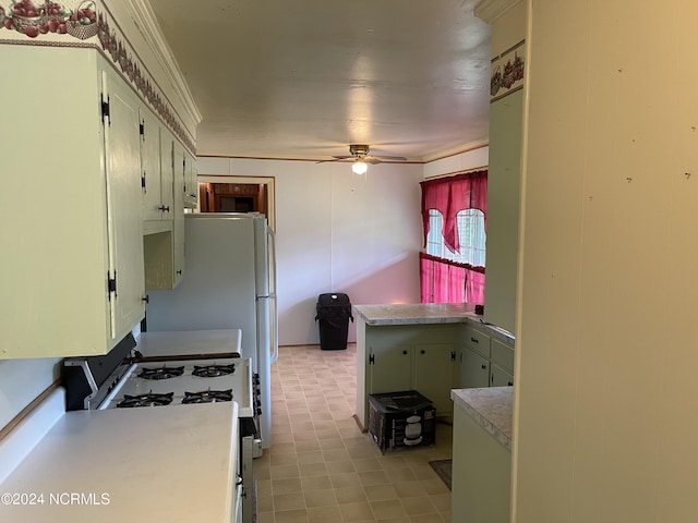 kitchen with light countertops, white gas stove, and ceiling fan