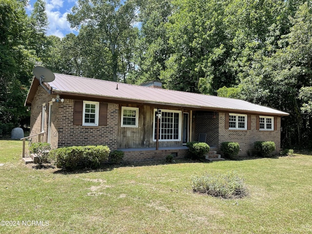 ranch-style house featuring a front yard, crawl space, brick siding, and metal roof