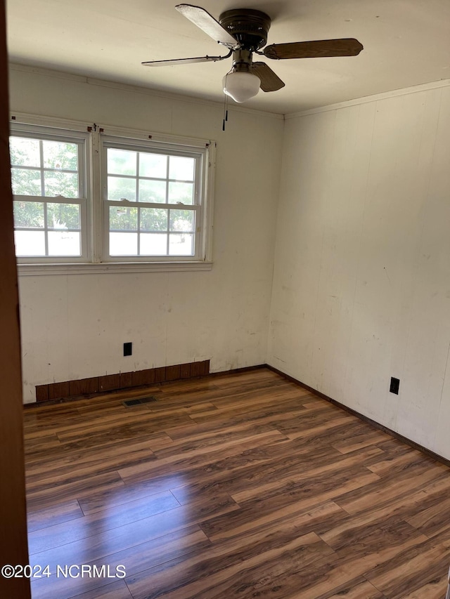 unfurnished room with dark wood-style floors, plenty of natural light, and visible vents