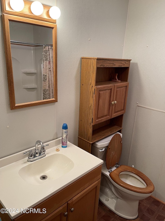 bathroom featuring a shower with shower curtain, vanity, and toilet