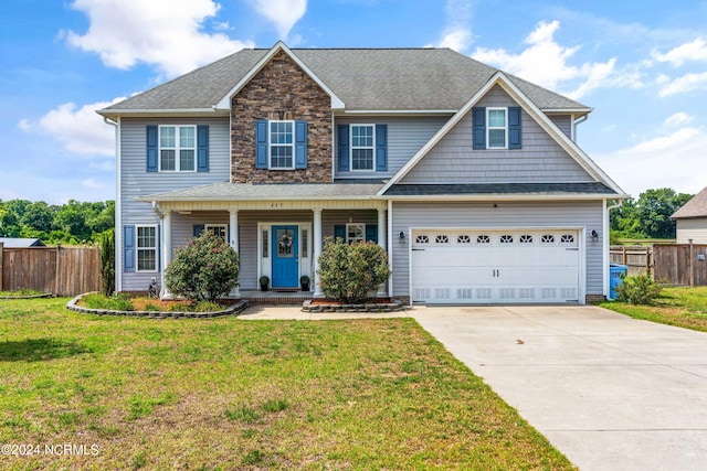 view of front of property featuring a front yard, covered porch, and a garage