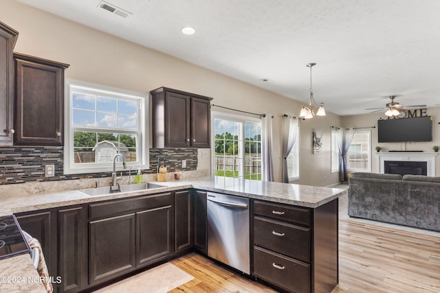 kitchen with dishwasher, kitchen peninsula, tasteful backsplash, and sink