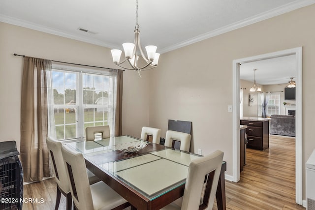 dining area featuring ceiling fan with notable chandelier, ornamental molding, and light hardwood / wood-style flooring