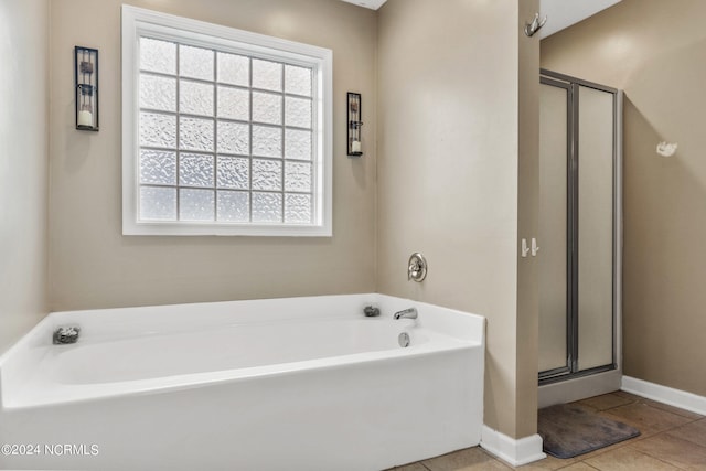 bathroom featuring separate shower and tub, a healthy amount of sunlight, and tile patterned flooring