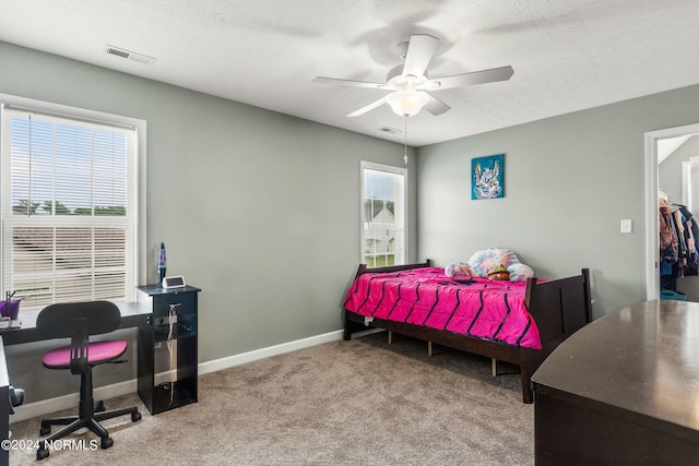 bedroom with ceiling fan, carpet, and a textured ceiling