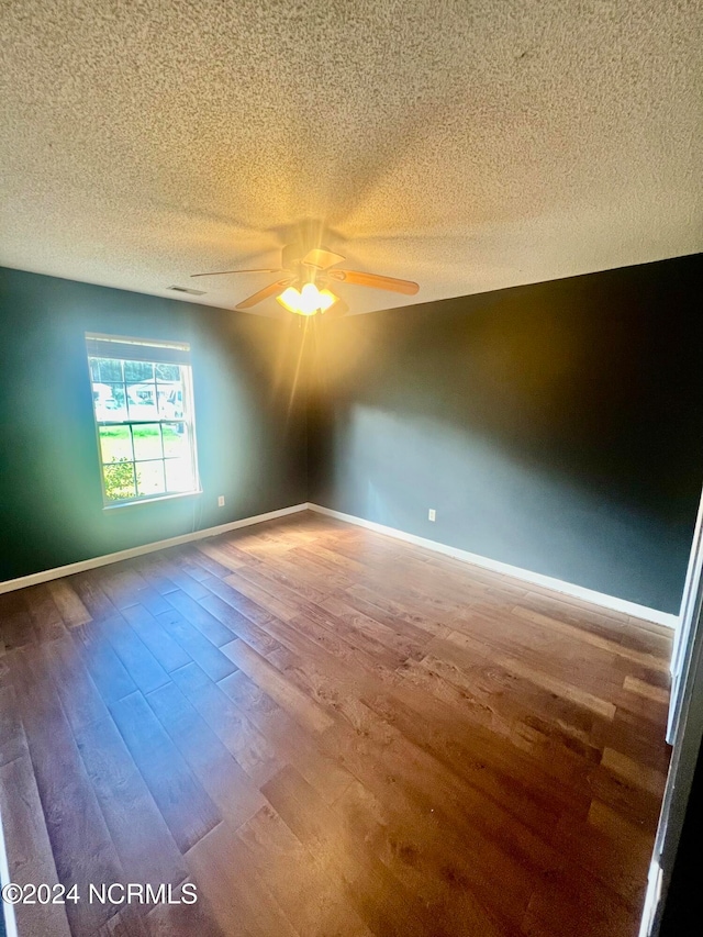 unfurnished room with a textured ceiling, ceiling fan, and wood-type flooring