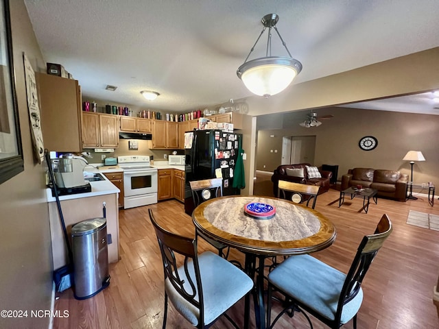 dining area with light wood-type flooring, ceiling fan, and sink