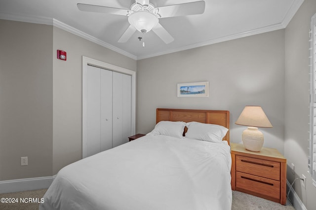 carpeted bedroom with crown molding, ceiling fan, and a closet