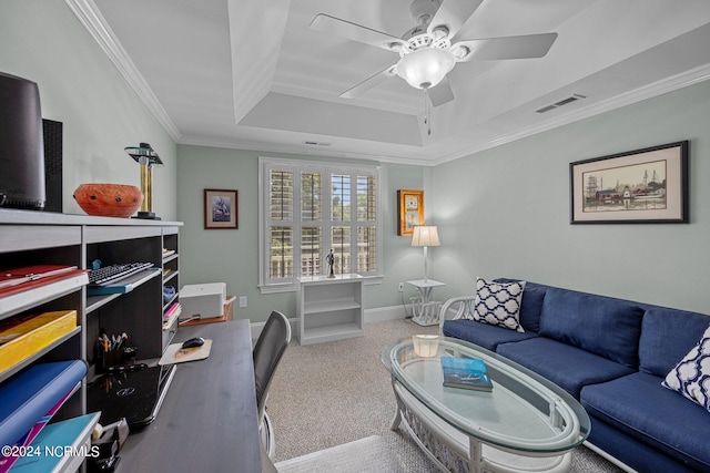 carpeted office with crown molding, a tray ceiling, and ceiling fan