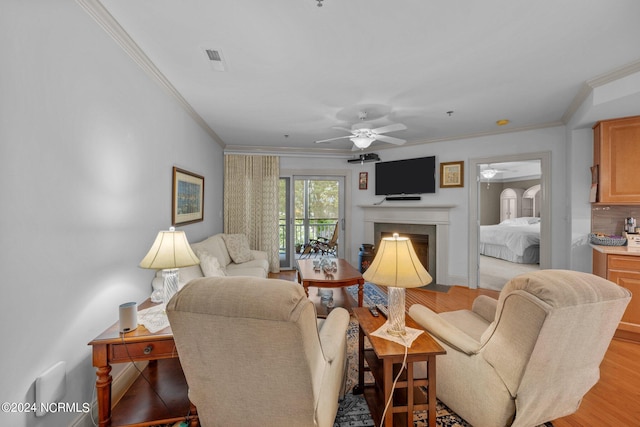 living room featuring ceiling fan, crown molding, and light hardwood / wood-style flooring