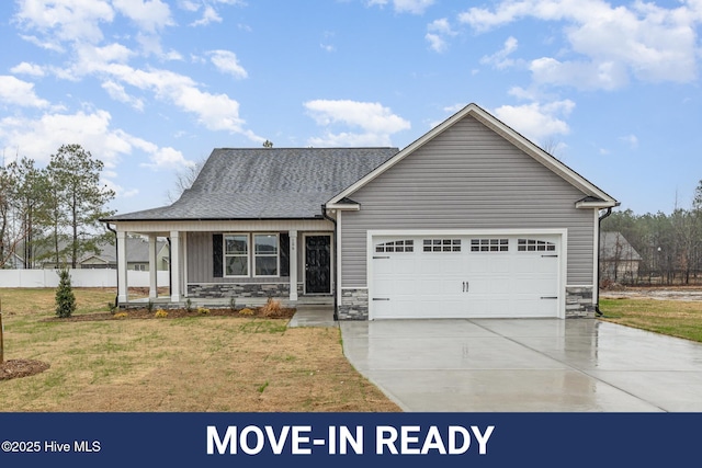 view of front of home featuring a garage, a front yard, and a porch