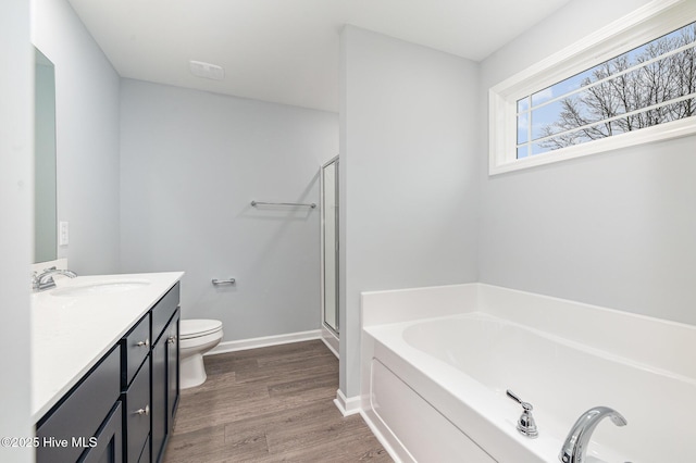 full bathroom featuring hardwood / wood-style flooring, vanity, independent shower and bath, and toilet