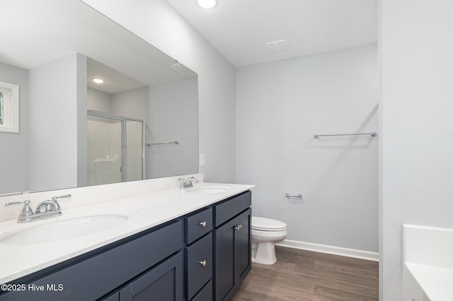 bathroom featuring vanity, hardwood / wood-style floors, a shower with door, and toilet