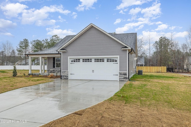 view of front of home with cooling unit, a garage, a front lawn, and covered porch