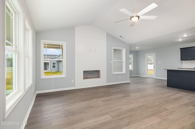 unfurnished living room with lofted ceiling, hardwood / wood-style flooring, and ceiling fan