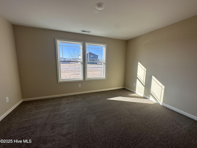 unfurnished room with dark colored carpet