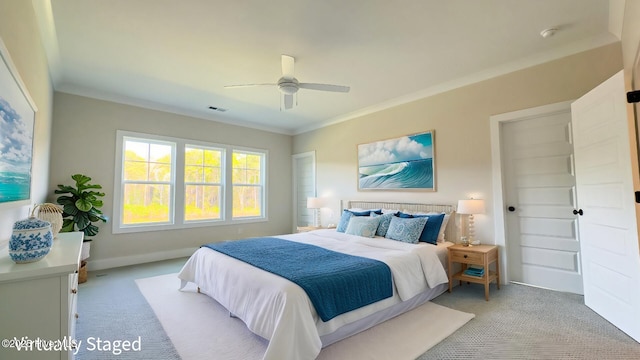 carpeted bedroom with ceiling fan and ornamental molding