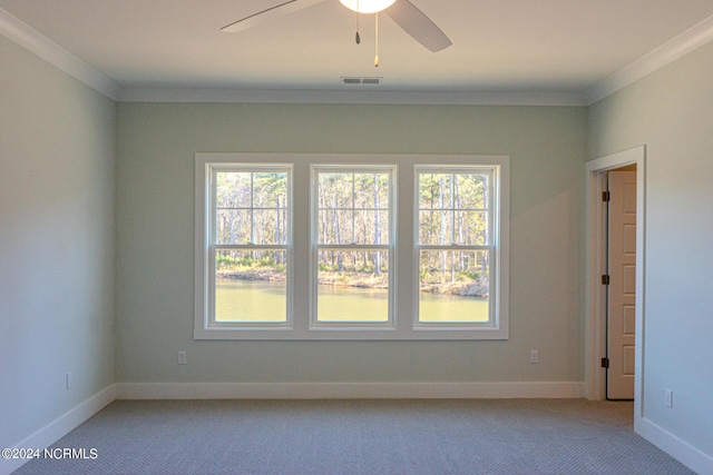 unfurnished room featuring light colored carpet, crown molding, and a wealth of natural light