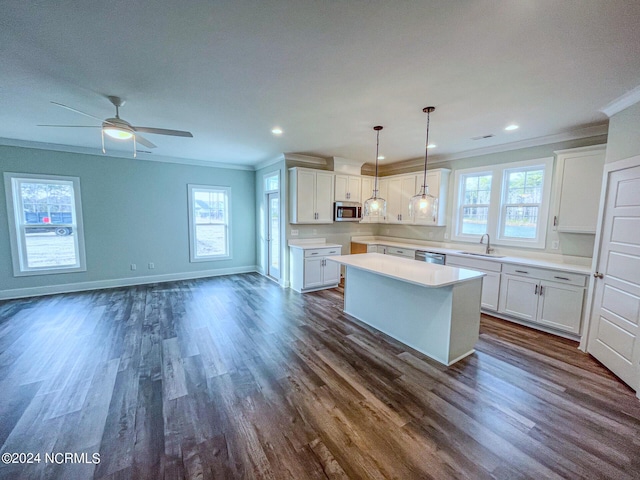 kitchen featuring white cabinets, a center island, appliances with stainless steel finishes, and sink