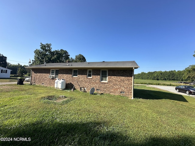 view of home's exterior with crawl space, a lawn, and brick siding