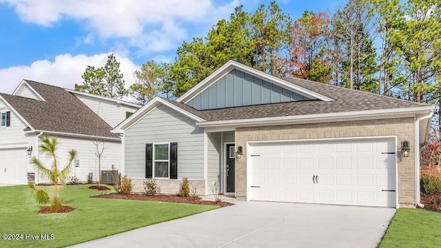 view of front of home featuring a front yard, a garage, and central air condition unit