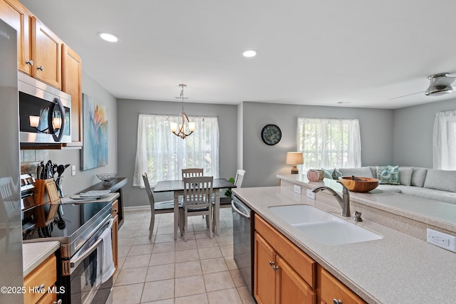 kitchen with a sink, appliances with stainless steel finishes, healthy amount of natural light, light countertops, and recessed lighting