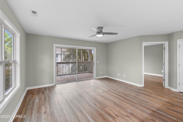 empty room with light hardwood / wood-style flooring, a wealth of natural light, and ceiling fan