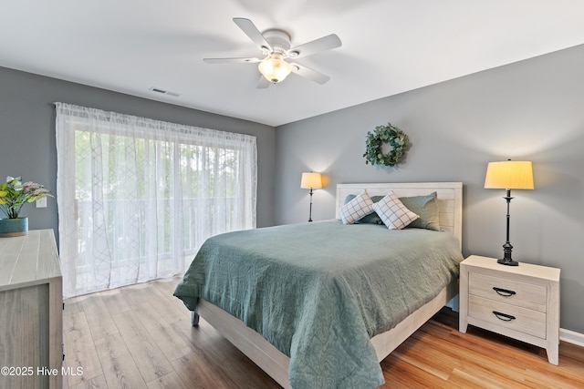 bedroom featuring wood finished floors, a ceiling fan, and baseboards