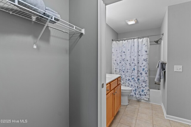 bathroom with tile patterned flooring, vanity, toilet, baseboards, and shower / bath combo