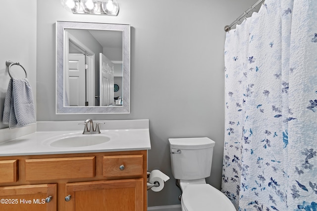 bathroom featuring toilet, vanity, and a shower with curtain