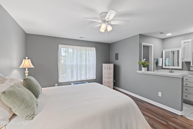 bedroom with dark wood-style floors, baseboards, a sink, and a ceiling fan