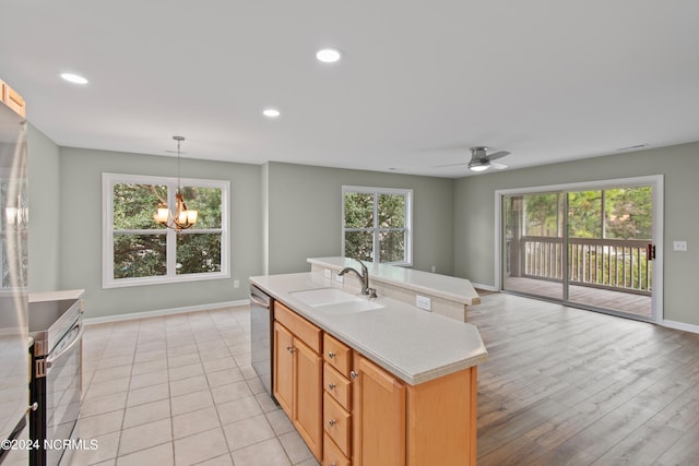 kitchen with a center island, ceiling fan with notable chandelier, sink, stainless steel dishwasher, and light hardwood / wood-style floors