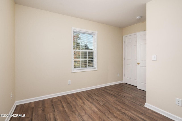 unfurnished room featuring dark wood-type flooring