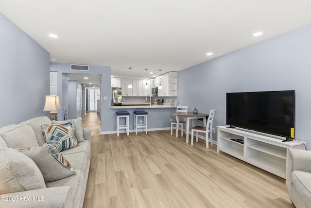 331 Salter Path Rd Unit 104, Pine Knoll Shores, NC 28512 - living room featuring light wood-style floors, recessed lighting, and baseboards