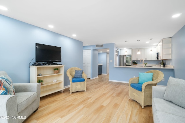 living room featuring sink and light wood-type flooring