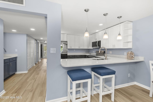 331 Salter Path Rd Unit 104, Pine Knoll Shores, NC 28512 - kitchen with stainless steel appliances, a sink, light wood-style floors, a breakfast bar, and recessed lighting