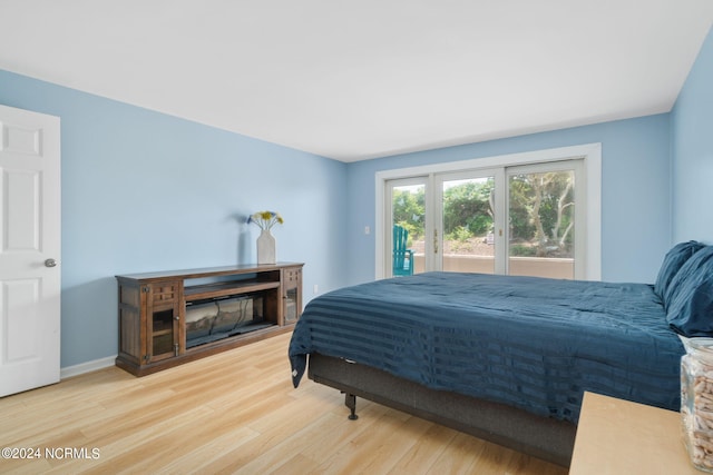 bedroom with access to exterior and hardwood / wood-style floors