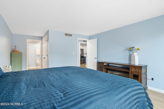 bedroom featuring light wood-type flooring and ensuite bathroom