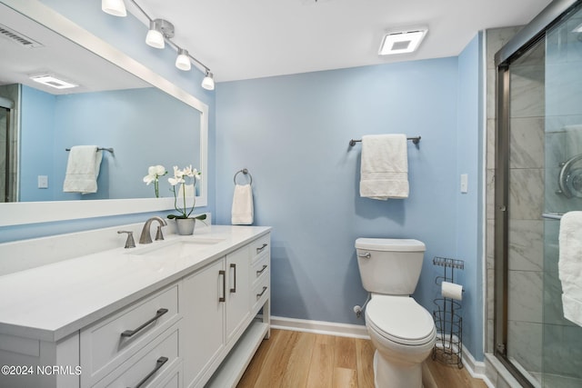 bathroom featuring vanity, hardwood / wood-style flooring, toilet, and an enclosed shower