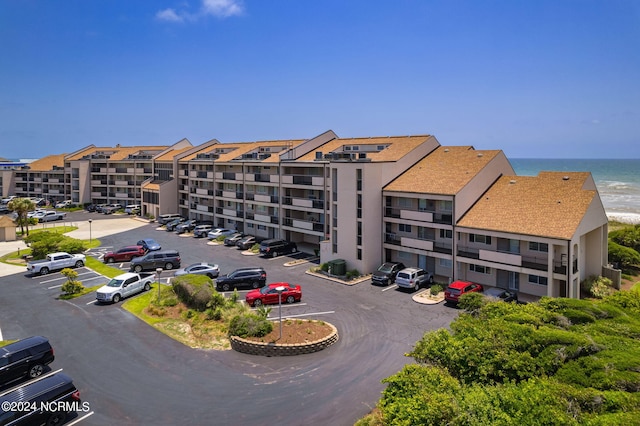 view of property featuring central air condition unit and a water view