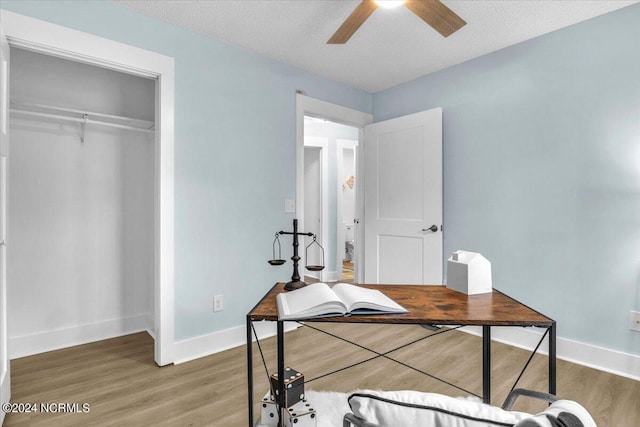 office space with ceiling fan, hardwood / wood-style floors, and a textured ceiling