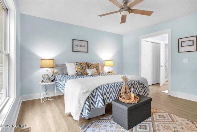 bedroom featuring ceiling fan, a textured ceiling, and light wood-type flooring