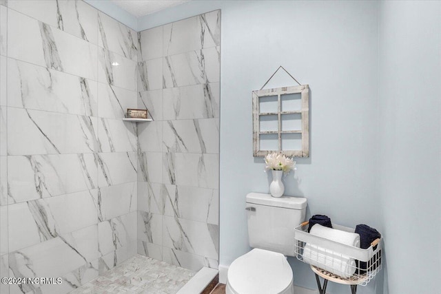 bathroom featuring tiled shower and toilet