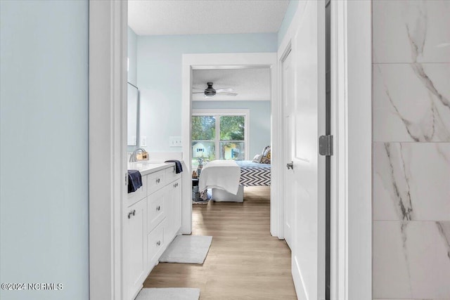 bathroom with vanity, a textured ceiling, hardwood / wood-style flooring, and ceiling fan