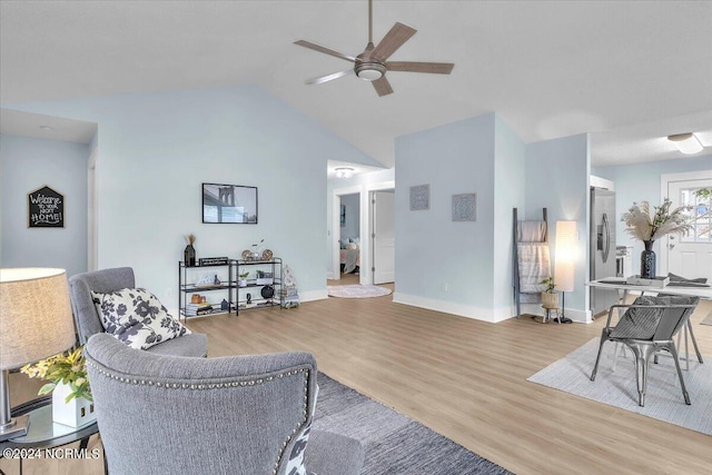 living room with light hardwood / wood-style floors, ceiling fan, and lofted ceiling