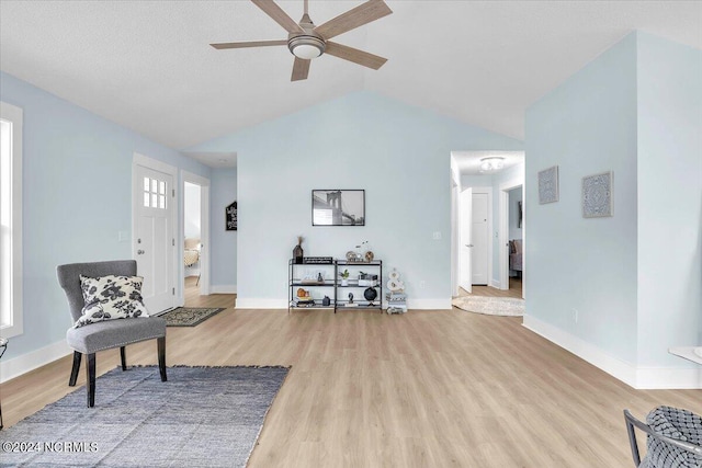 sitting room featuring ceiling fan, light wood-type flooring, and lofted ceiling