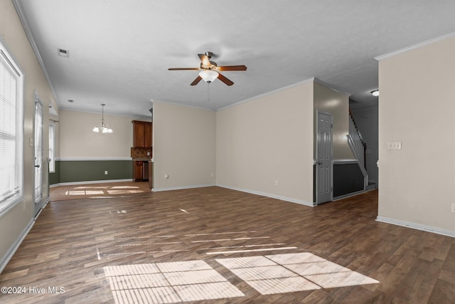 unfurnished living room with a textured ceiling, crown molding, dark wood-type flooring, and ceiling fan with notable chandelier