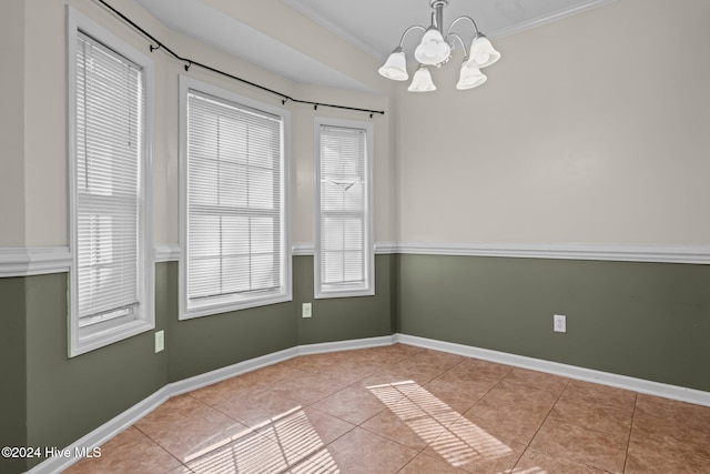 unfurnished room featuring light tile patterned floors, a notable chandelier, and ornamental molding